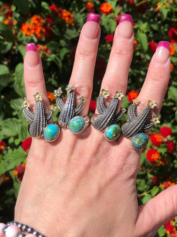 A hand with four cactus rings on it