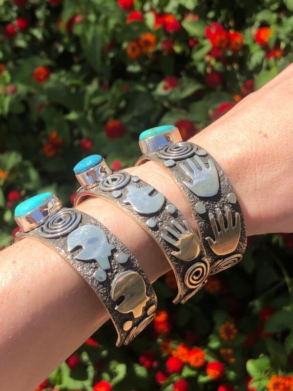 Three bracelets with a hand and palm design on them.