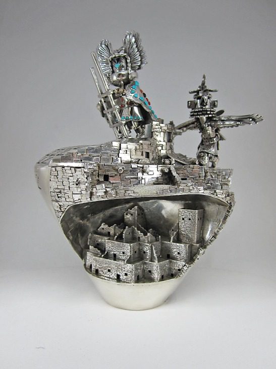 A silver sculpture of a ship with a man on it.