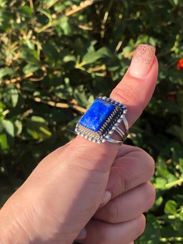 A person holding up a blue stone ring
