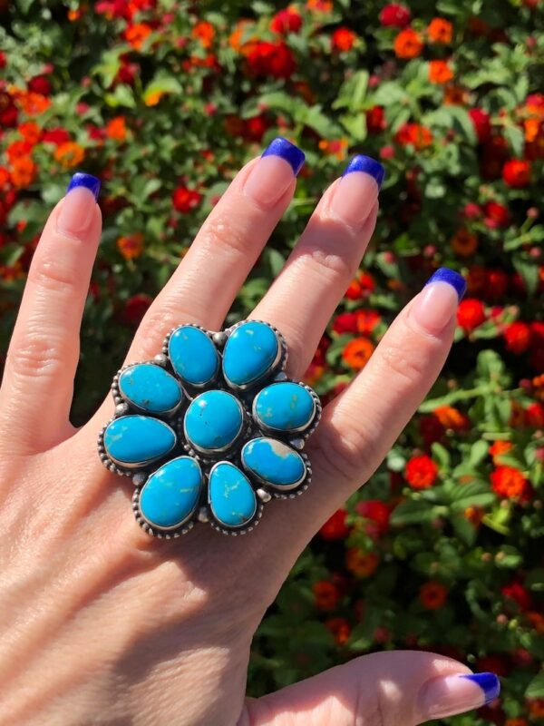 A person is holding onto a ring of turquoise