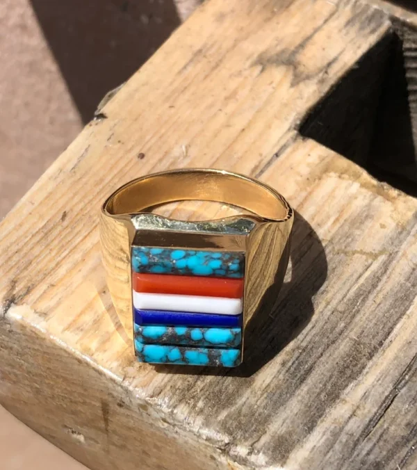 A gold ring with some different colored stones on it