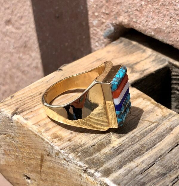 A gold ring sitting on top of a wooden box.