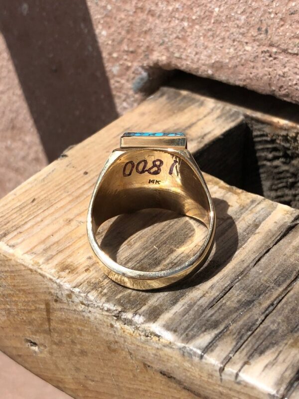 A gold ring sitting on top of a wooden box.