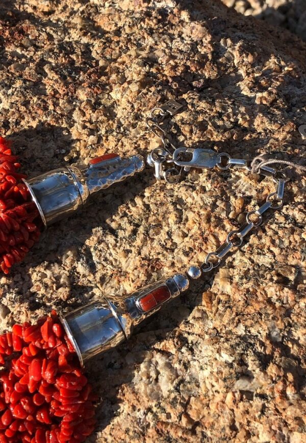 A pair of red and silver keys on the ground.