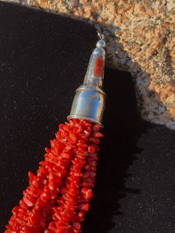 A close up of the red coral bead tassel.