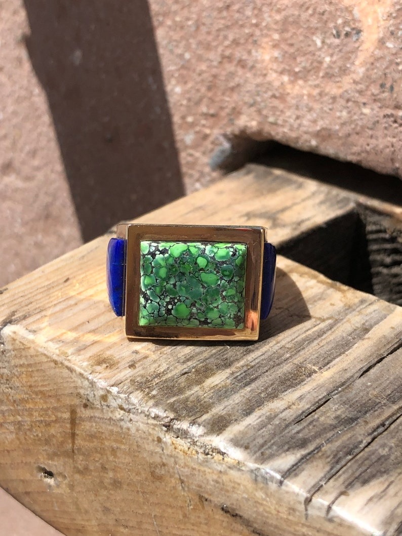 A square green stone on top of a wooden block.