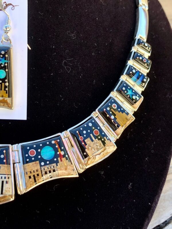 A necklace and earrings set with blue, black and gold designs.