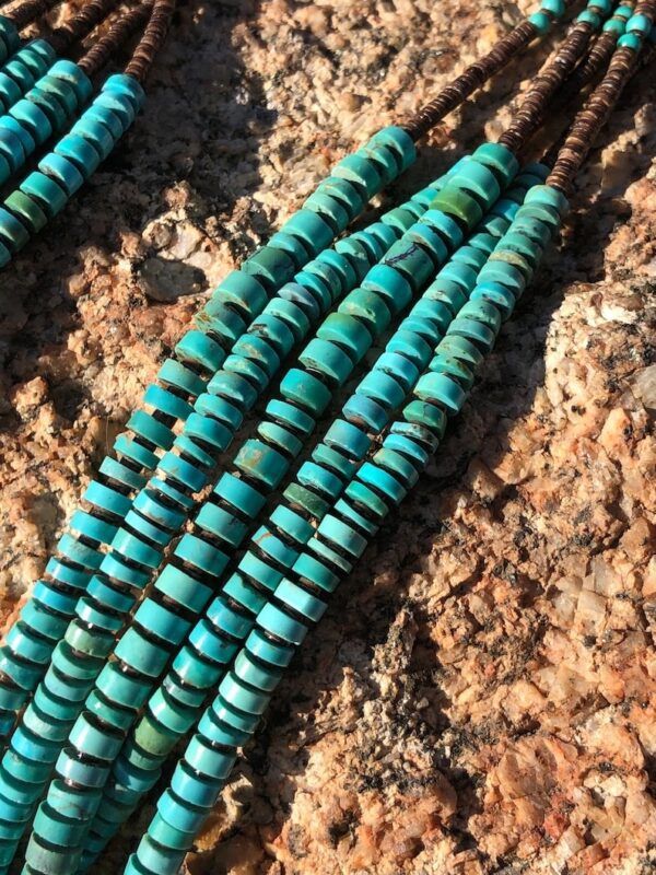 A close up of some turquoise beads on the ground