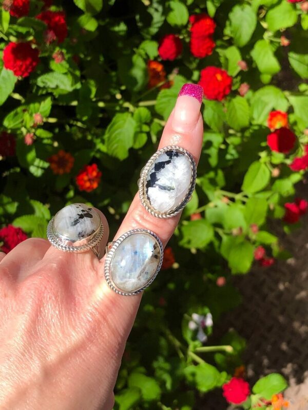 A person holding onto some rings in front of flowers