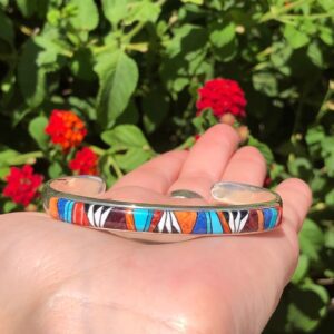 A person holding onto a colorful bracelet