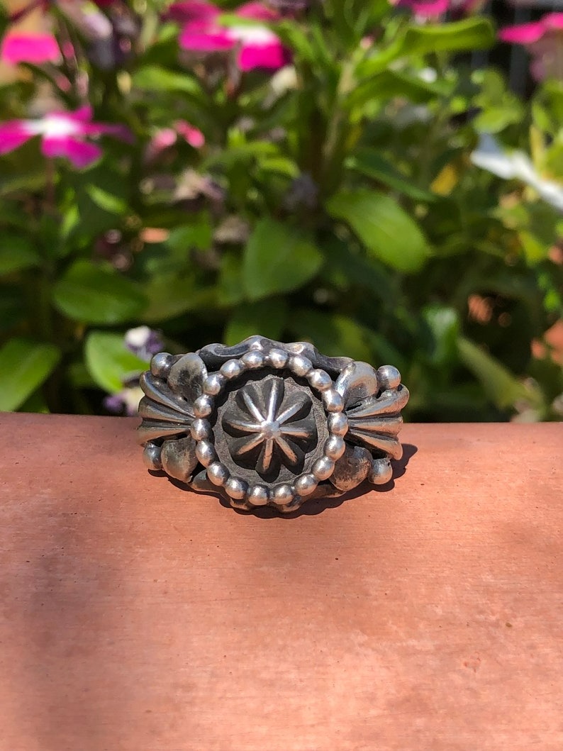 A silver ring sitting on top of a wooden table.
