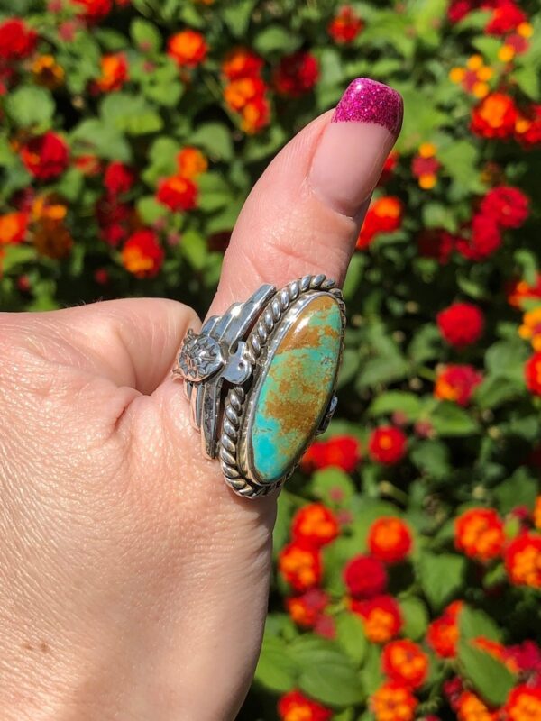 A woman is holding onto the ring of turquoise
