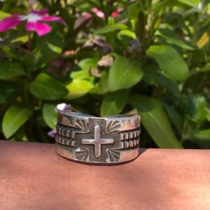 A silver bracelet with a cross on it