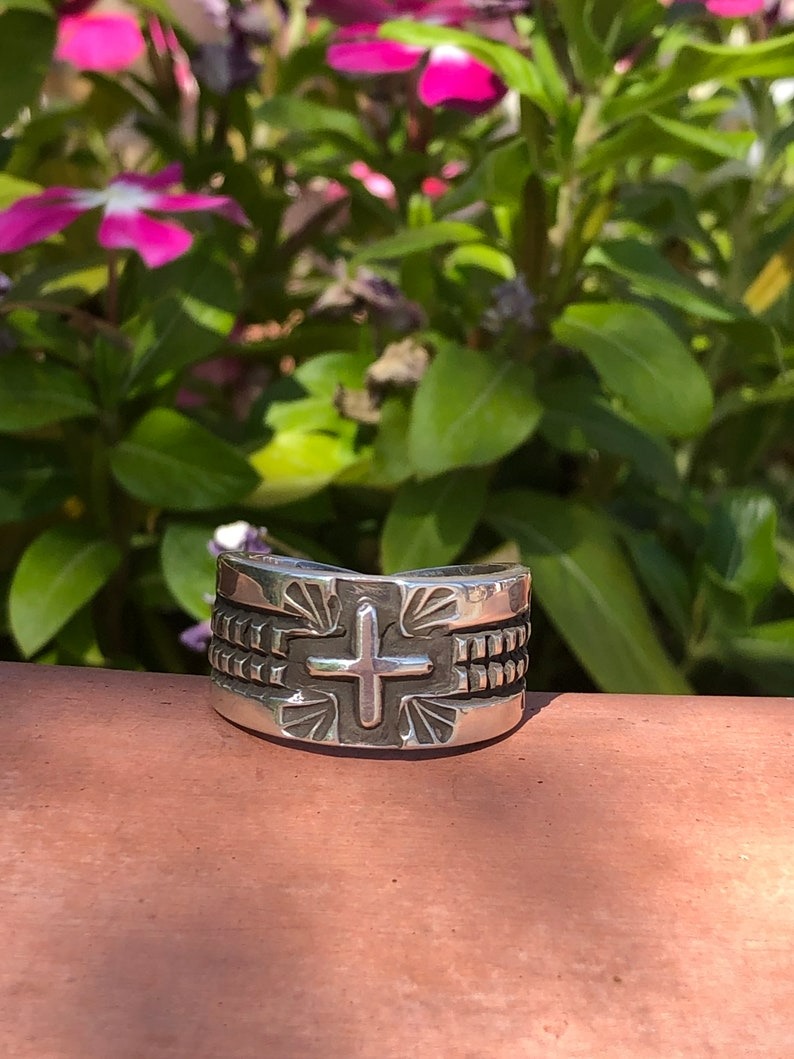 A silver bracelet with a cross on it