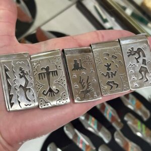 A hand holding five different metal cigarette cases.