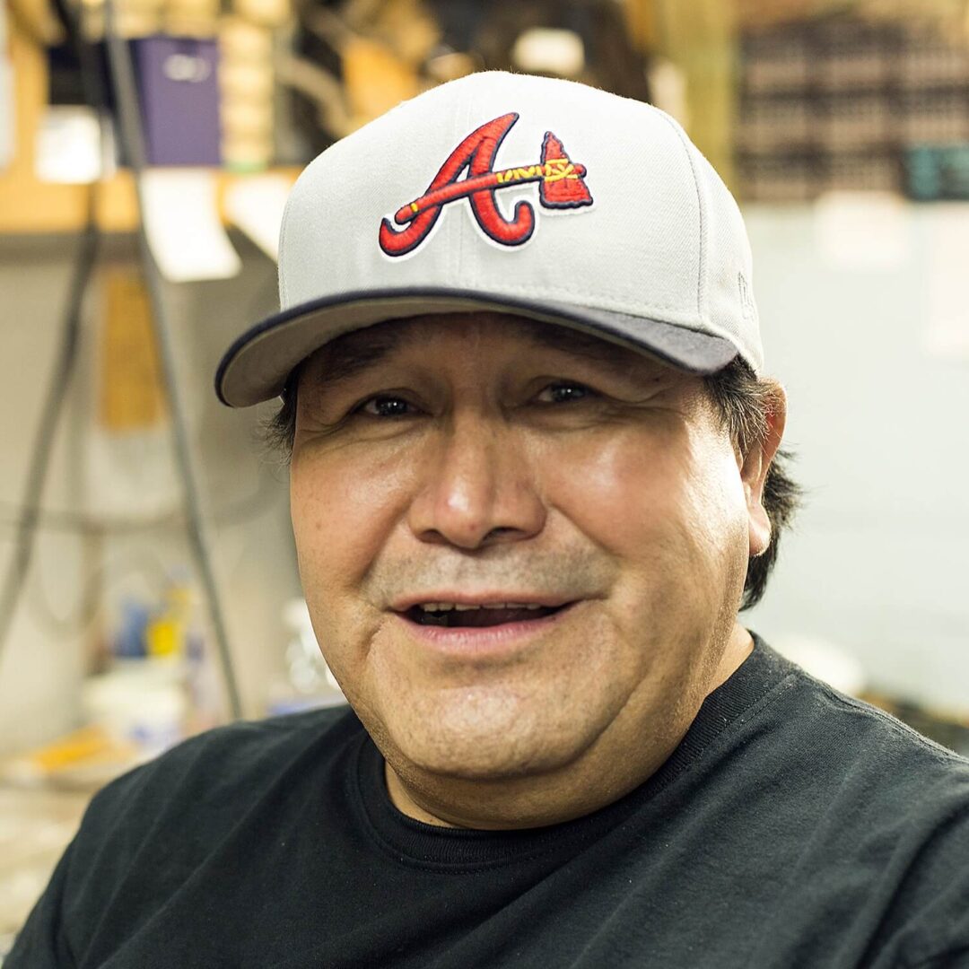 A man wearing a baseball cap and smiling.