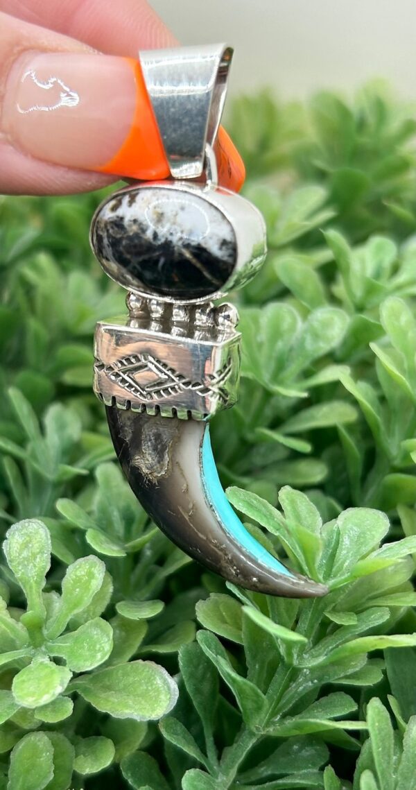 A silver and turquoise ring with a large claw.