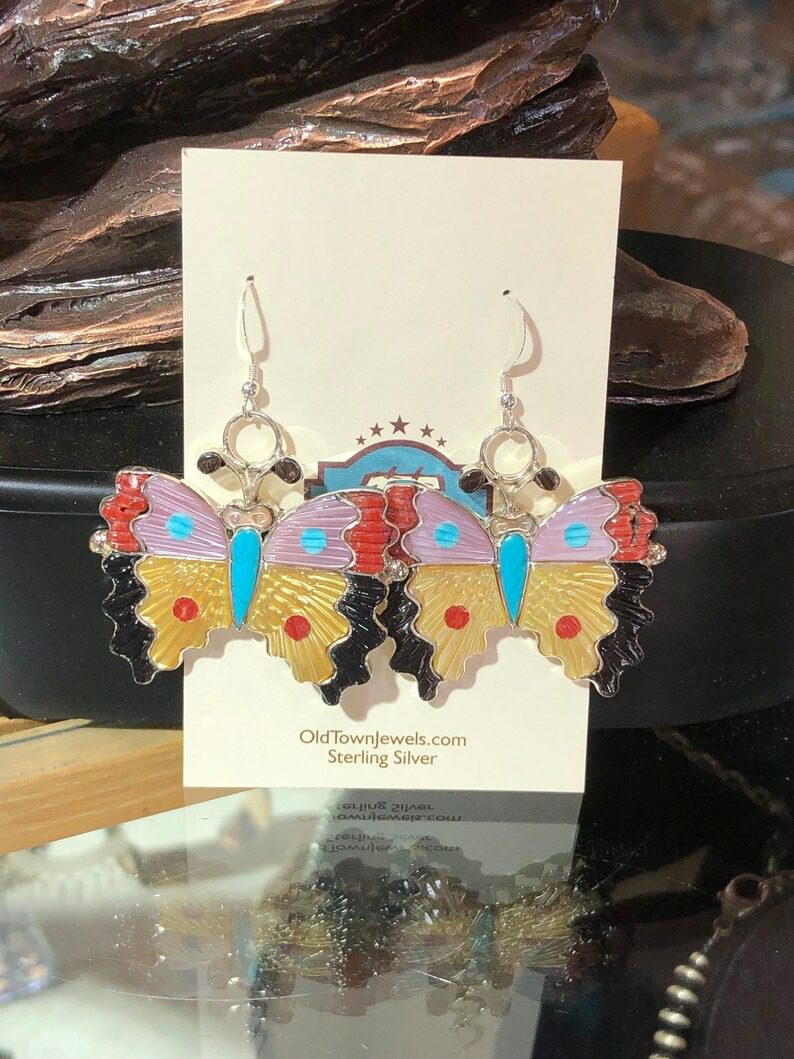 A pair of earrings hanging on a card.