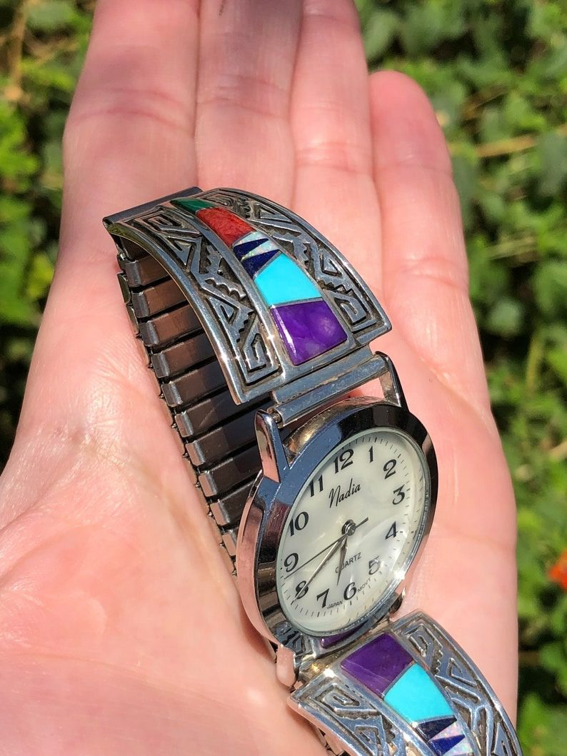 A person holding their watch in the palm of their hand.