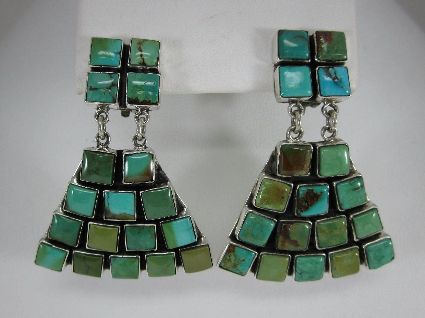 A pair of turquoise earrings hanging from the side.