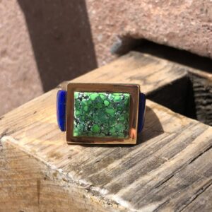 A green stone ring on top of a wooden bench.