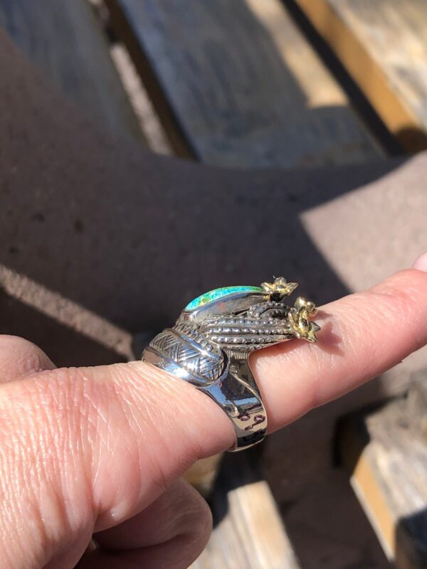 Sterling silver ring with green stone and gold flowers.