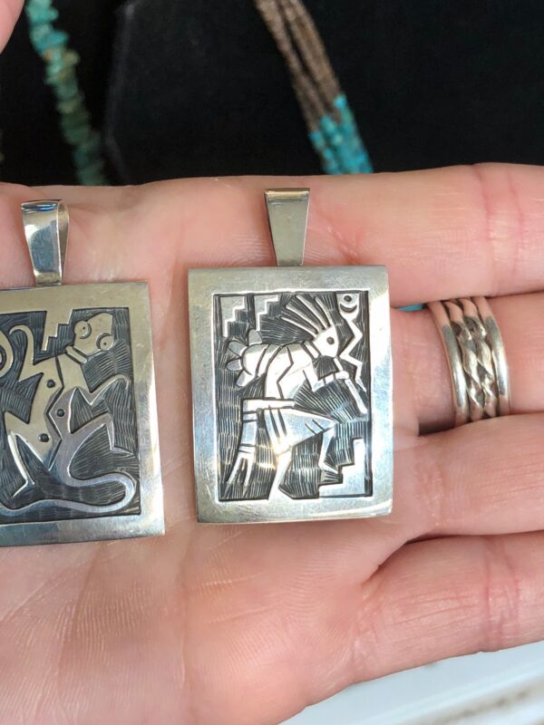 Two silver pendants with Native American designs.