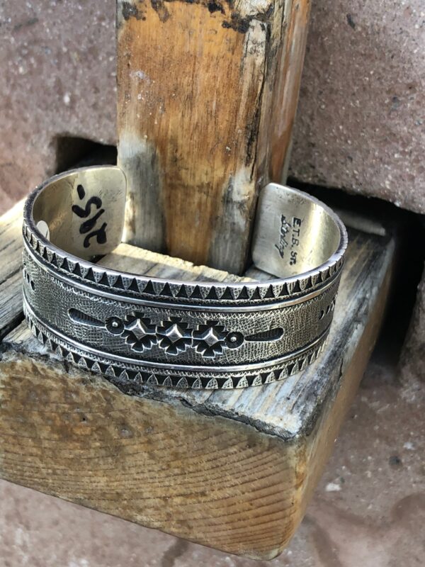 A silver cuff bracelet with geometric designs.
