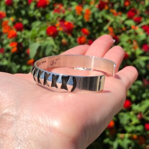 A silver cuff bracelet with a unique design.