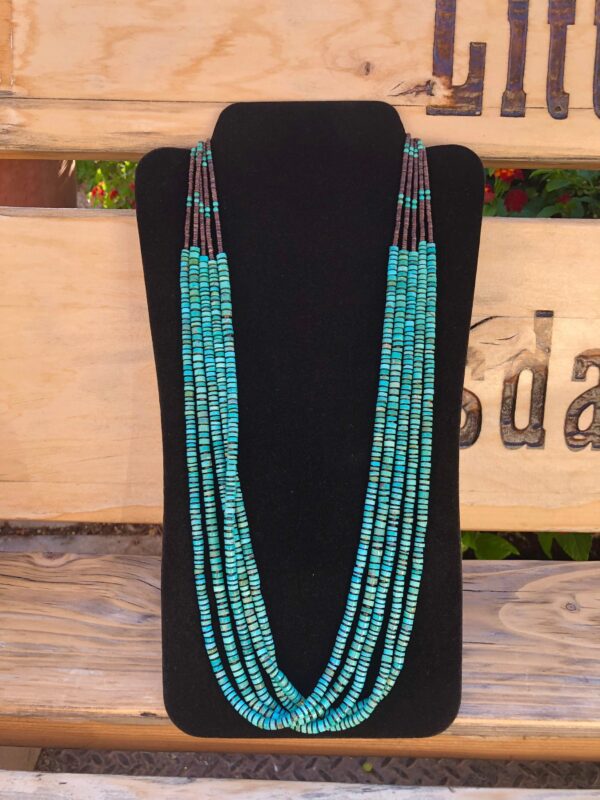 Multi-strand turquoise bead necklace on stand.