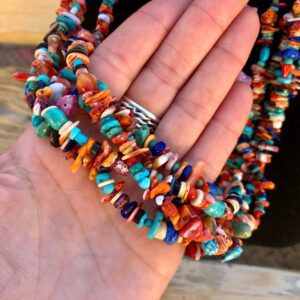 A person holding a colorful beaded necklace.