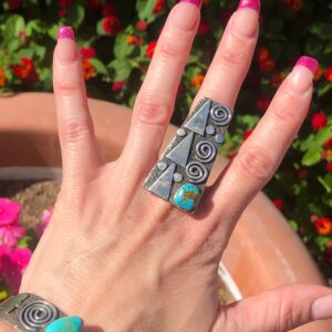 A woman's hand with a turquoise ring on it.