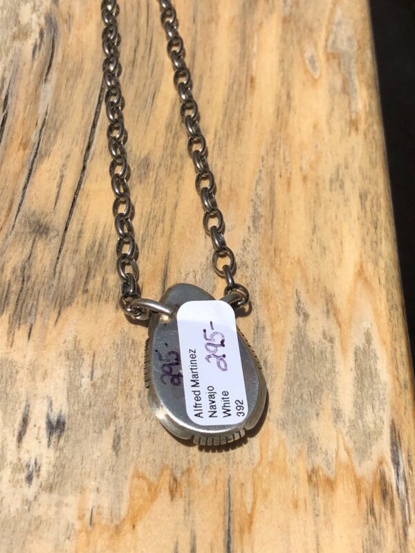 A silver pendant with a blue stone on a silver chain.