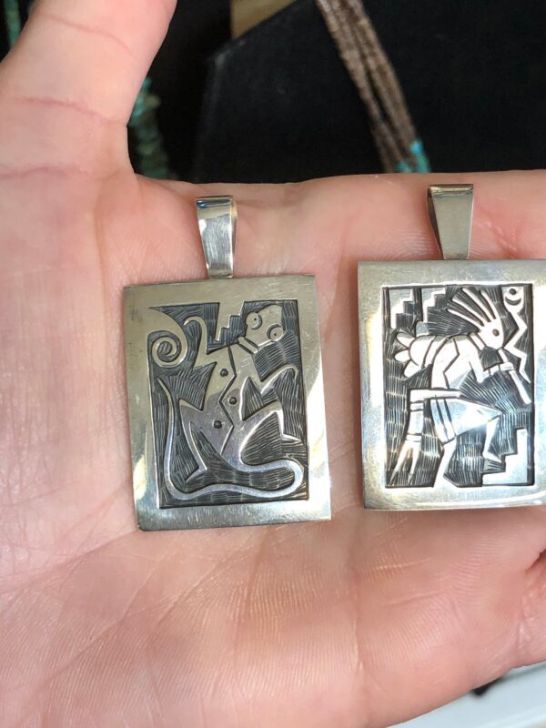 Two silver pendants with Native American designs.