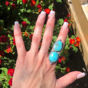 A woman's hand with a turquoise stone ring.