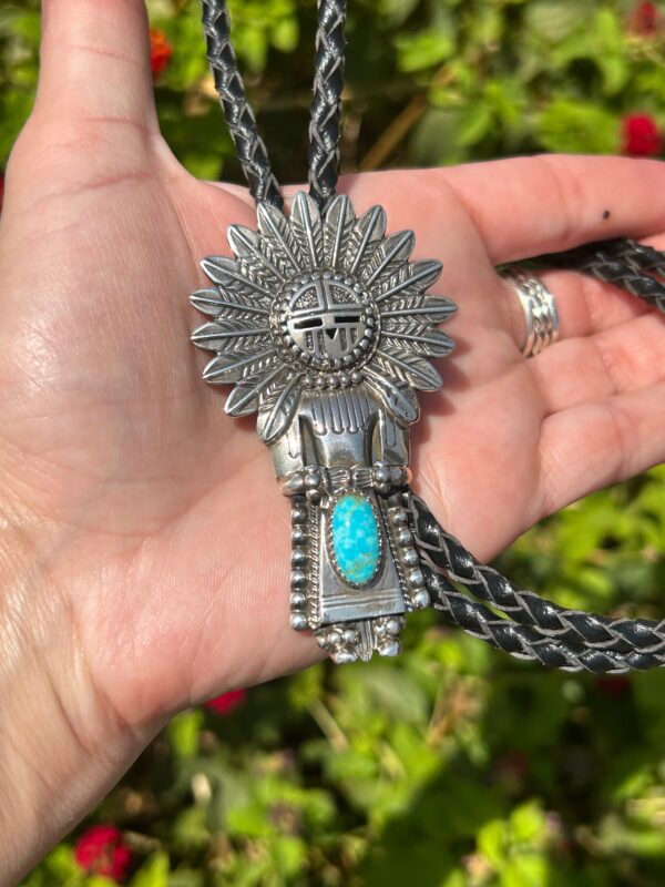 A person holding a necklace with an indian head on it.