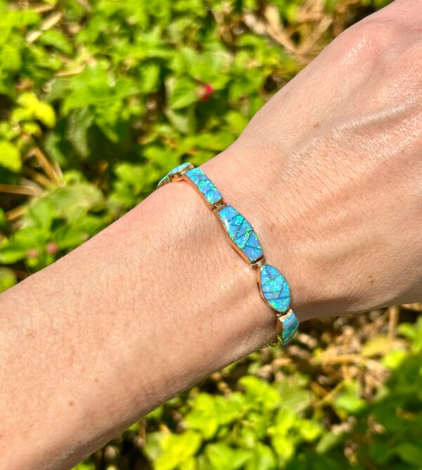 A woman wearing a blue opal bracelet.