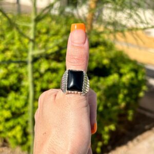 Hand wearing a black gemstone ring.