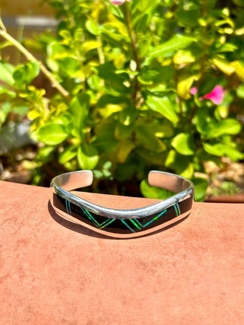 A black and green cuff bracelet on a table.