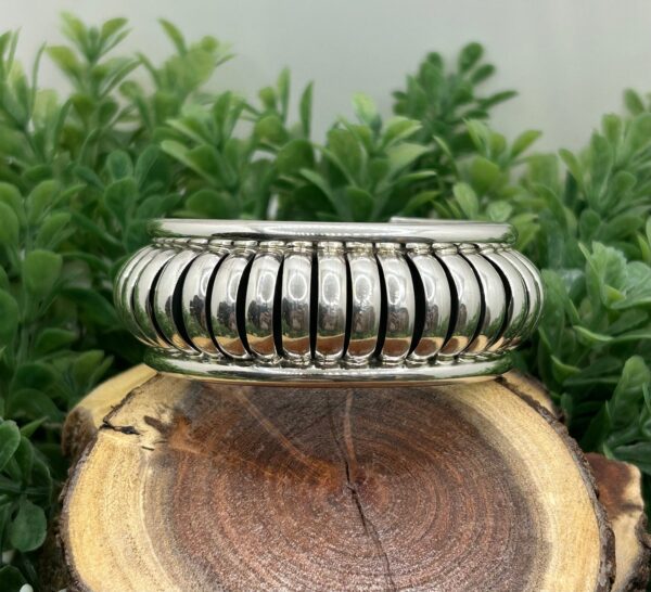 A silver cuff bracelet with a ribbed design.