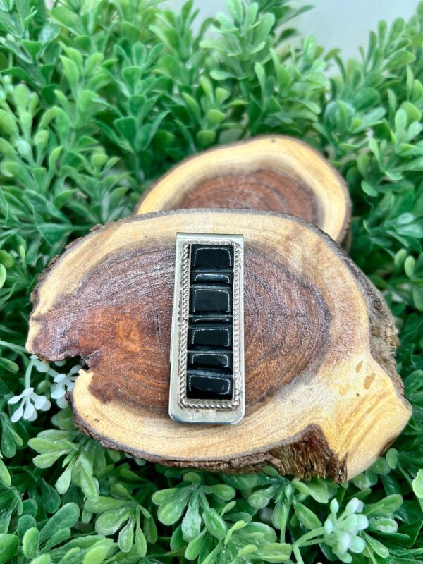 A black onyx ring on top of a piece of wood.