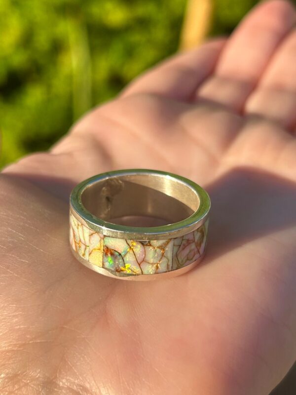 Crafted silver ring with colorful inlays.