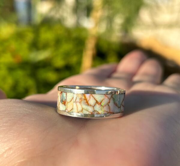 Crafted silver ring with colorful opal inlay.