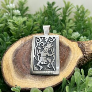 A silver pendant with an image of a man with a sword.
