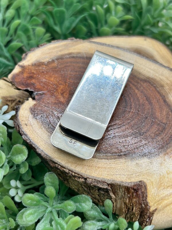 Sterling silver money clip on wood.