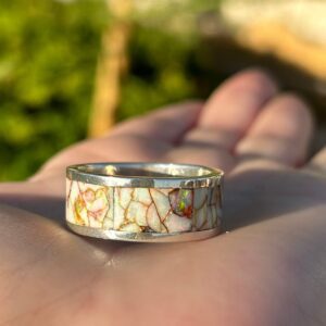 Crafted silver ring with colorful inlays.