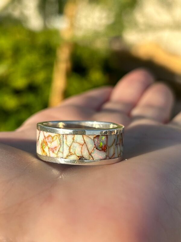 Crafted silver ring with colorful inlays.