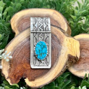 A silver money clip with a turquoise stone.
