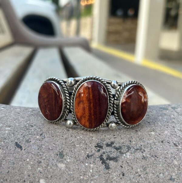 Silver bracelet with three red stones.